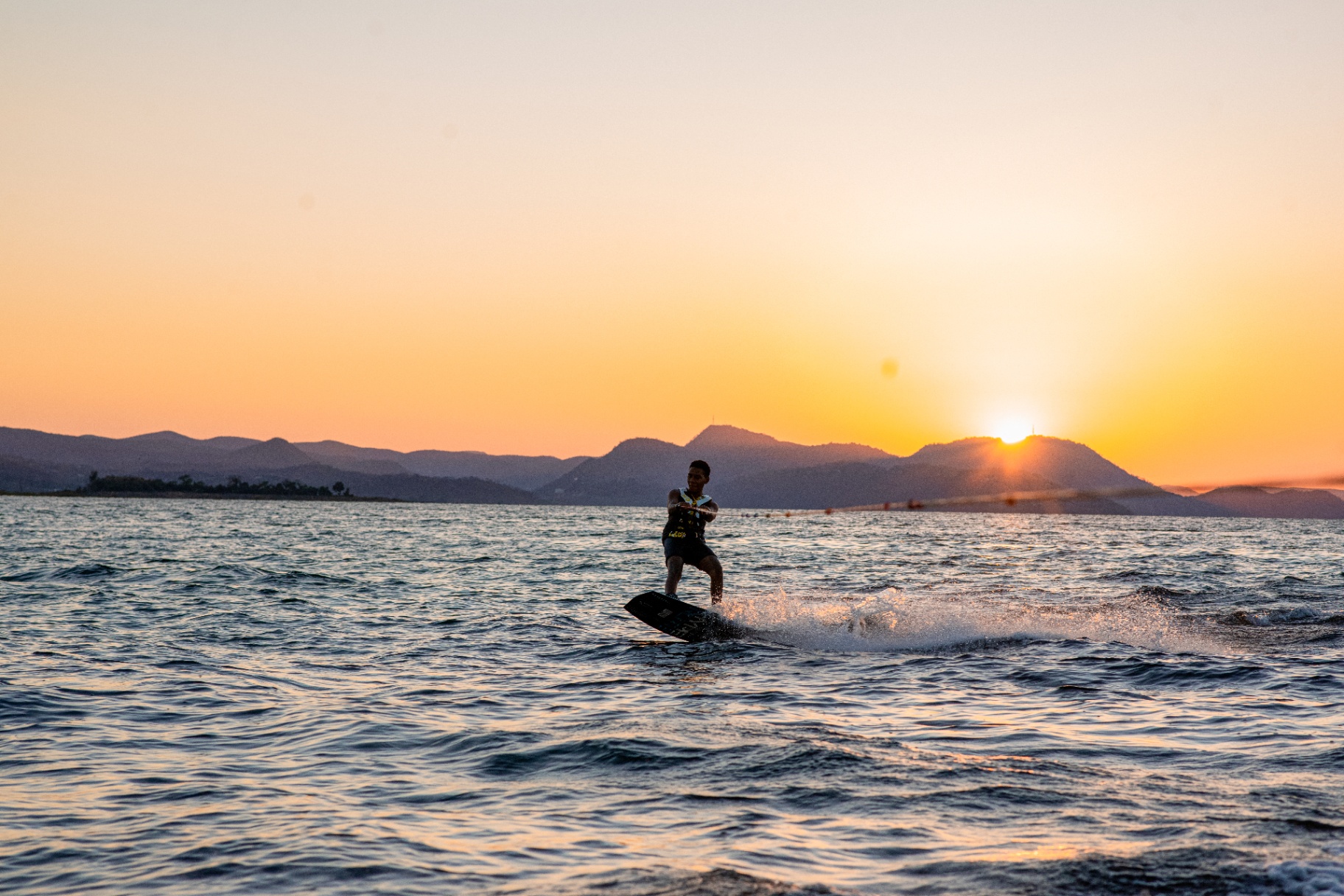 Golden-hour wakeboarding silhouette