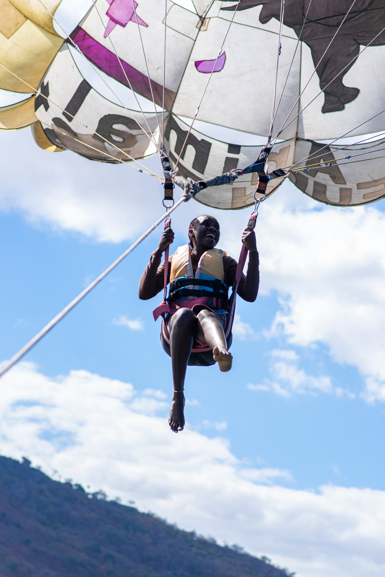 Guest smiling mid-paraglide
