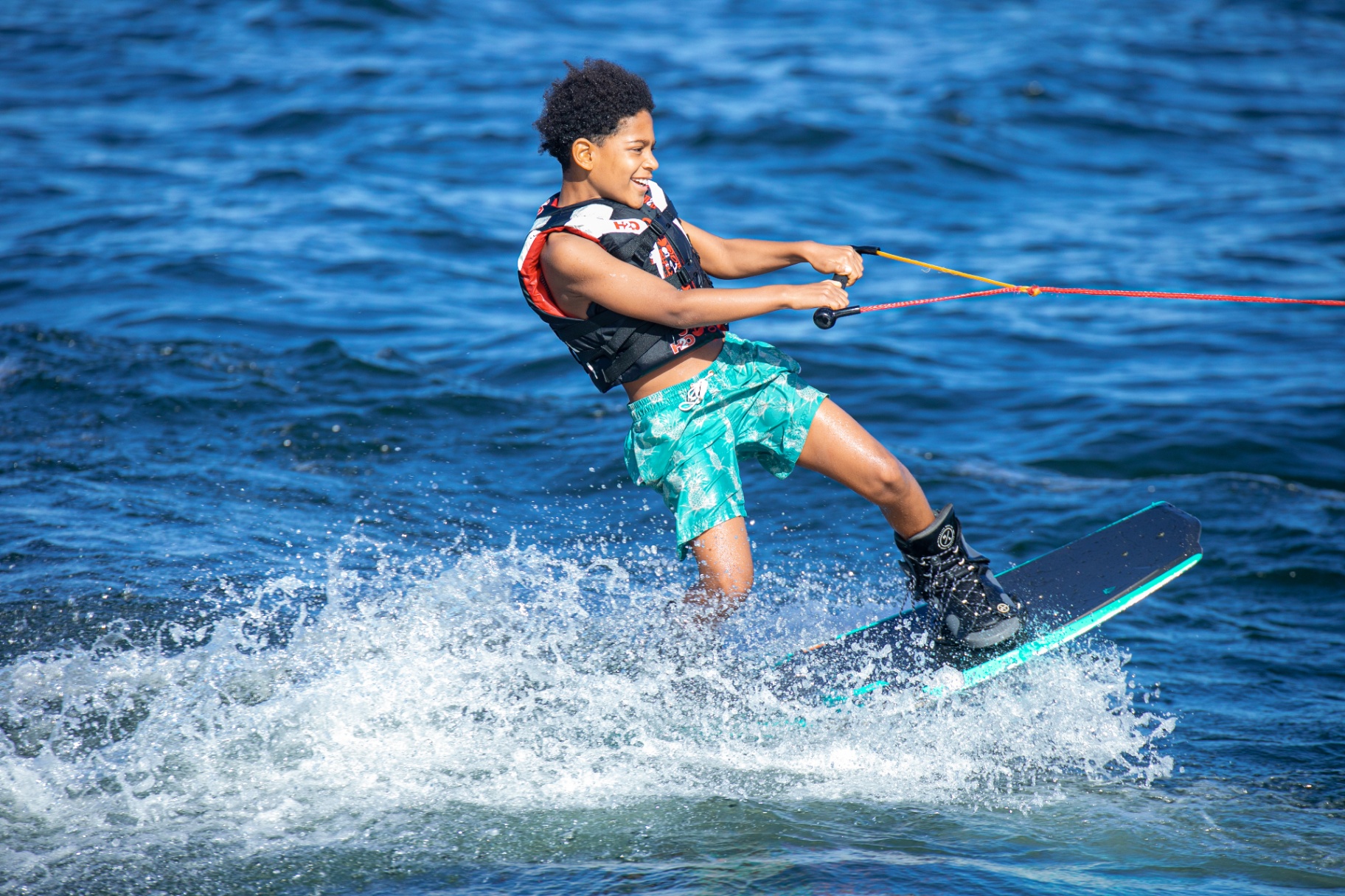 Kid wakeboarding with a big smile